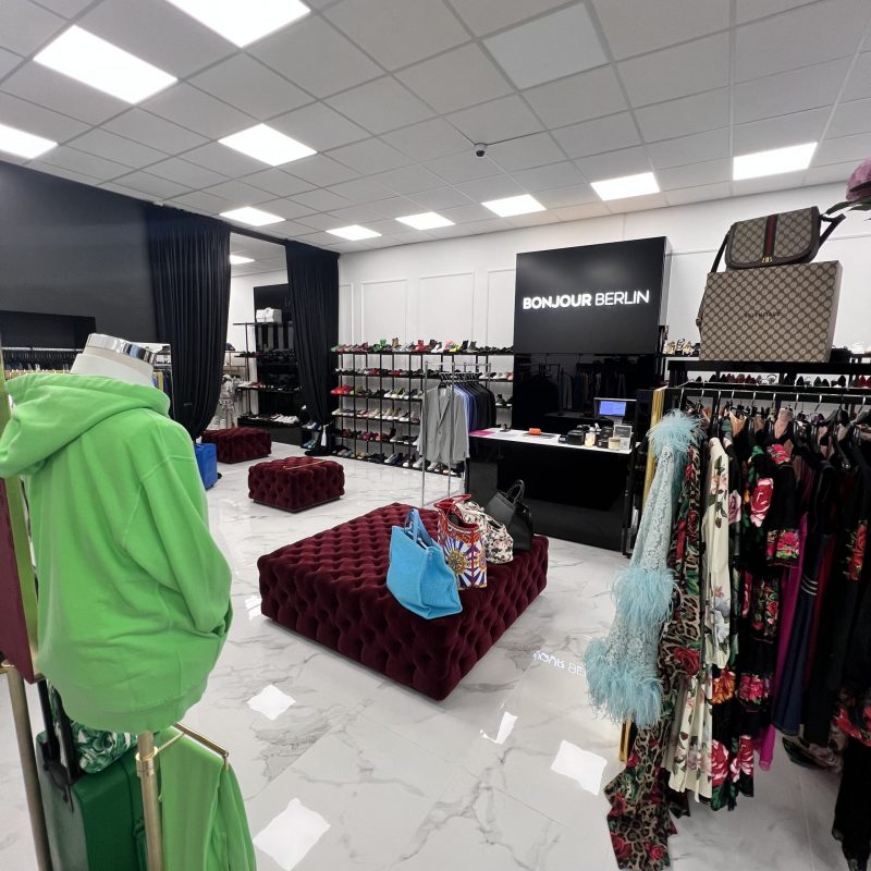 Stilvolle Innenansicht des Bonjour Berlin Geschäfts Innenansicht des Bonjour Berlin High Fashion Geschäfts. Der Raum ist modern und luxuriös gestaltet, mit stilvollen Kleiderständern und Auslagen, die exklusive Mode von Dolce & Gabbana präsentieren. Große Spiegel und dezente Beleuchtung verstärken die elegante Atmosphäre.